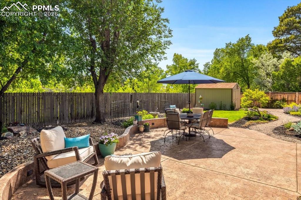 Image 41 of 48: Fenced backyard featuring outdoor lounge area, a storage shed, and a patio