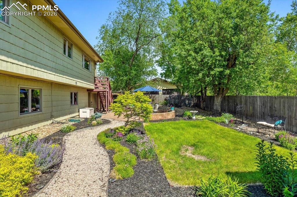 Image 43 of 48: Fenced backyard featuring a patio area and stairs