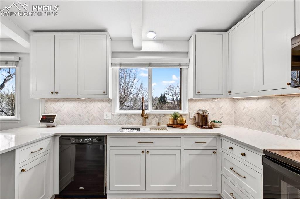 Image 9 of 48: Kitchen featuring black appliances, white cabinets, and light stone counter
