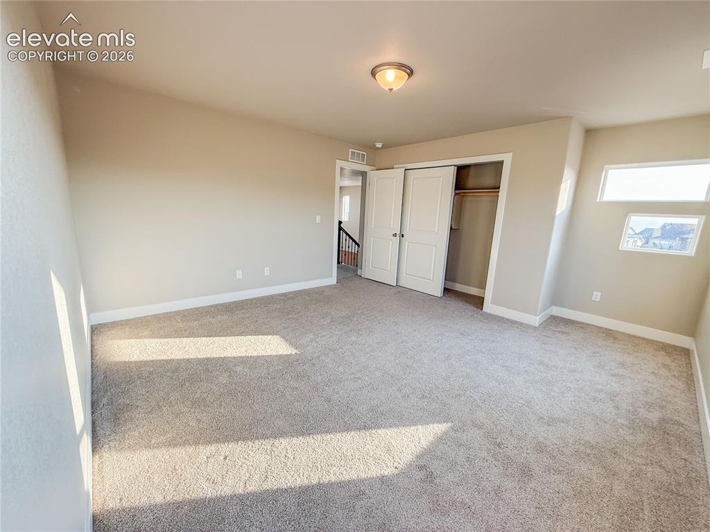 Image 30 of 50: Virtually Staged Upper level bedroom with walk in closet.