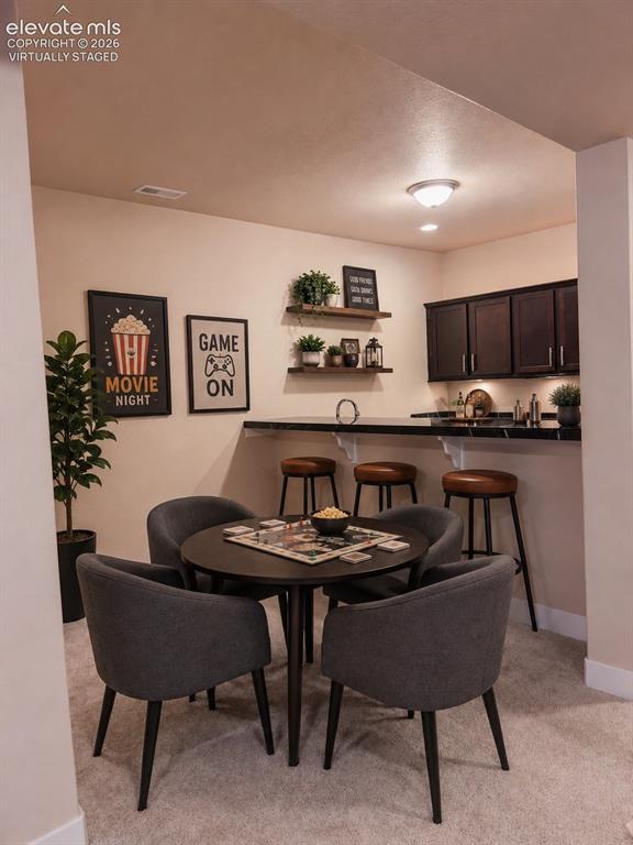Image 37 of 50: Basement kitchenette/wet bar with mini fridge and dishwasher. Granite count