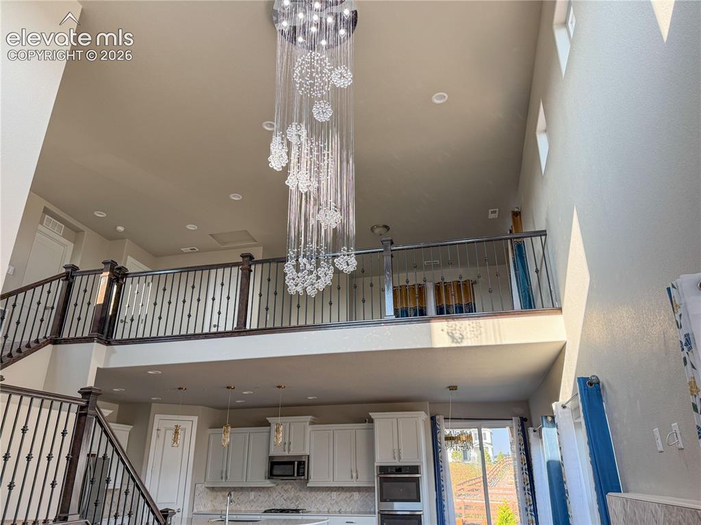 Image 8 of 50: From Loft stairs to the  Living Room with  Modern Chandelier