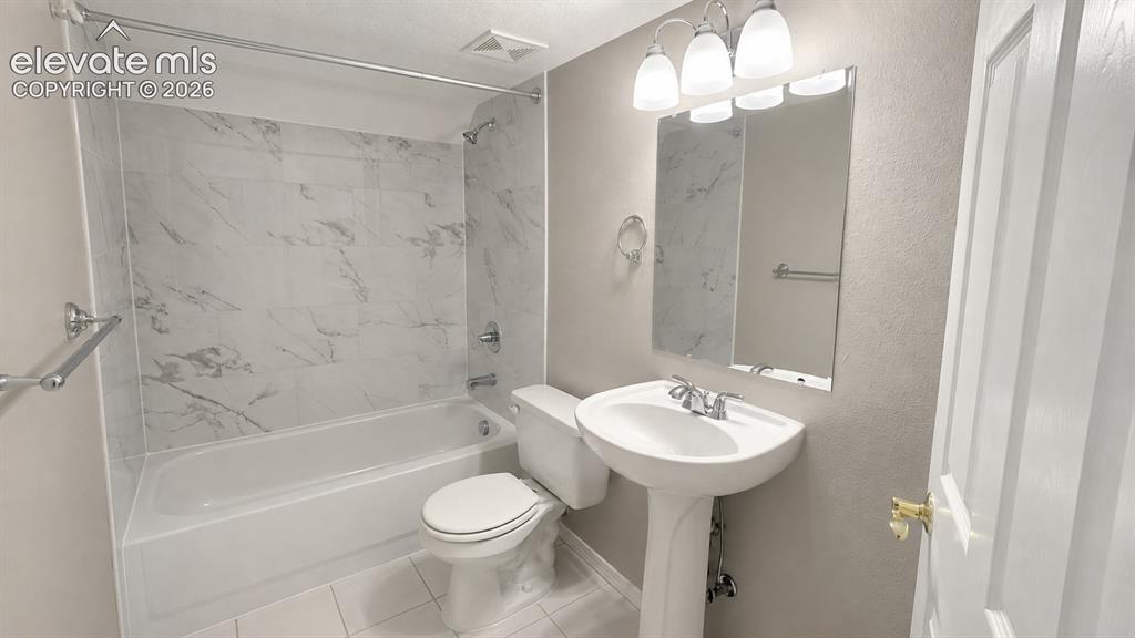 Image 17 of 25: Pedestal sink with chrome faucet, wall-mounted mirror, three-light vanity f