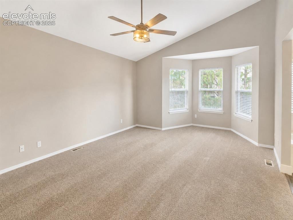 Image 18 of 25: Vaulted ceiling with a ceiling fan, bay window with three vertical windows,