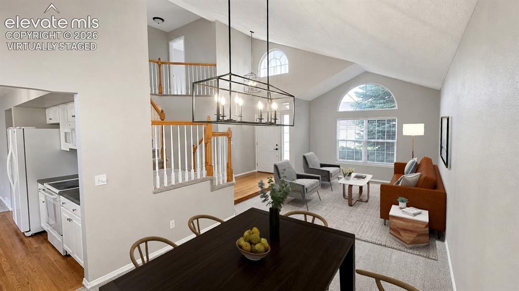 Image 2 of 25: Vaulted ceilings with an arched window, a contemporary chandelier, and a sp