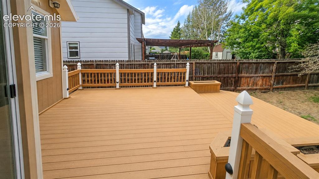 Image 23 of 25: Expansive multi-level composite deck with white balusters and wood-finish r