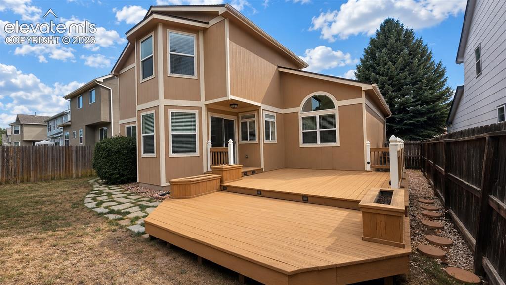 Image 25 of 25: Multi-level composite deck with built-in planters, stone pathway, and priva