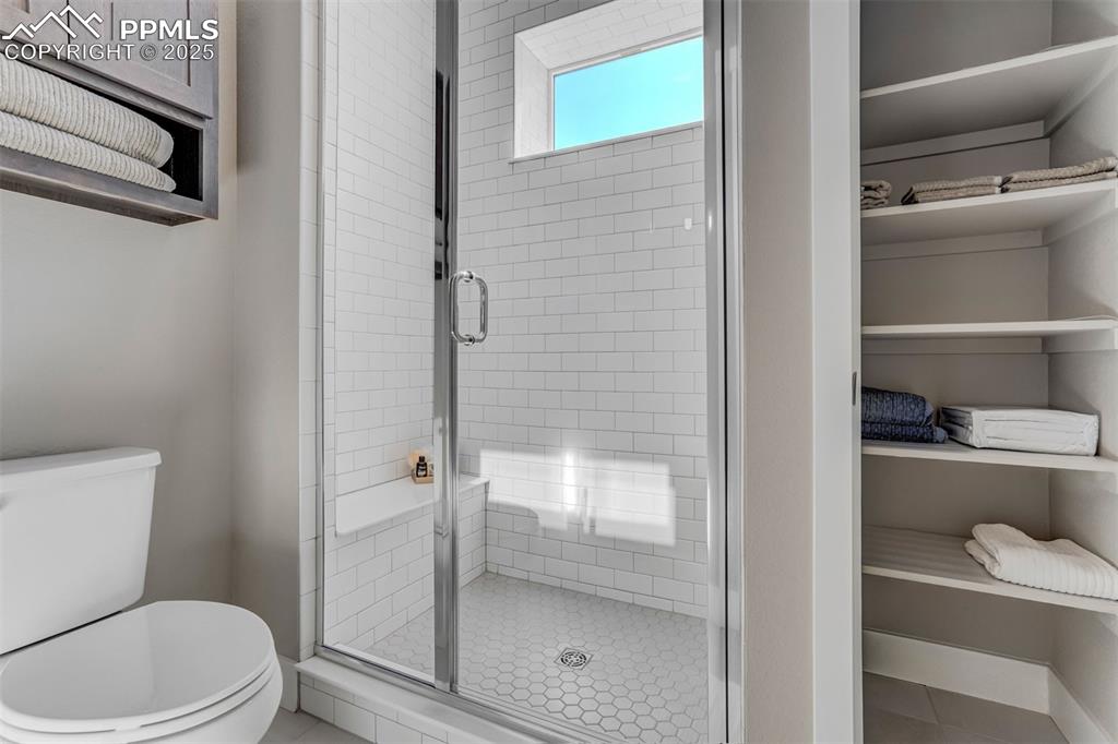Image 31 of 42: Bathroom with a shower stall, tile patterned flooring, and a closet