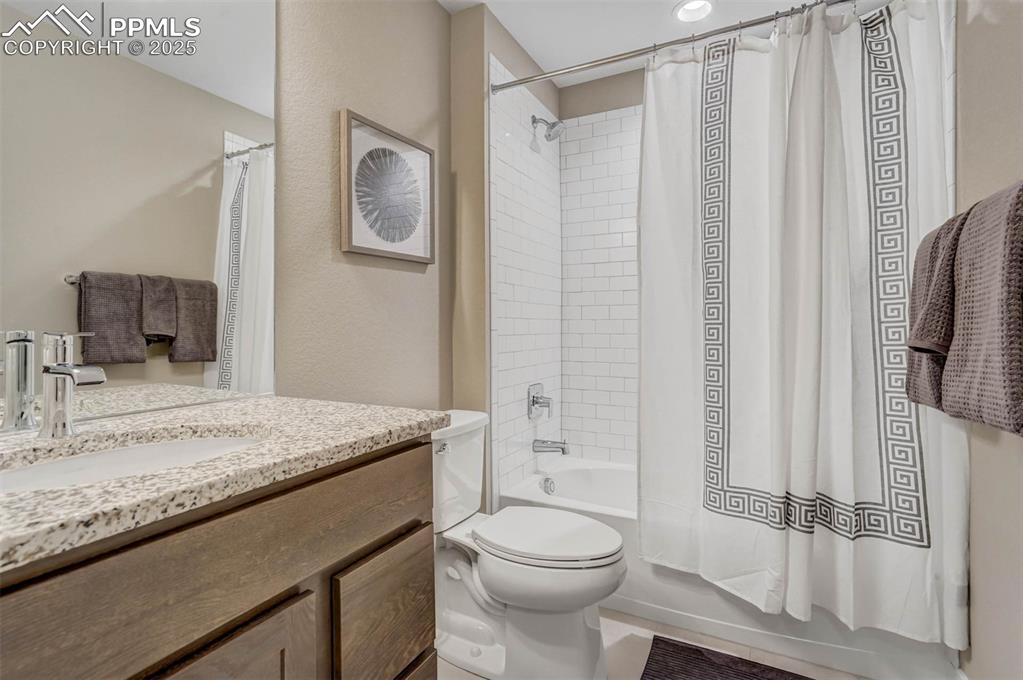 Image 33 of 42: Full bathroom featuring shower / bath combination with curtain, vanity, and