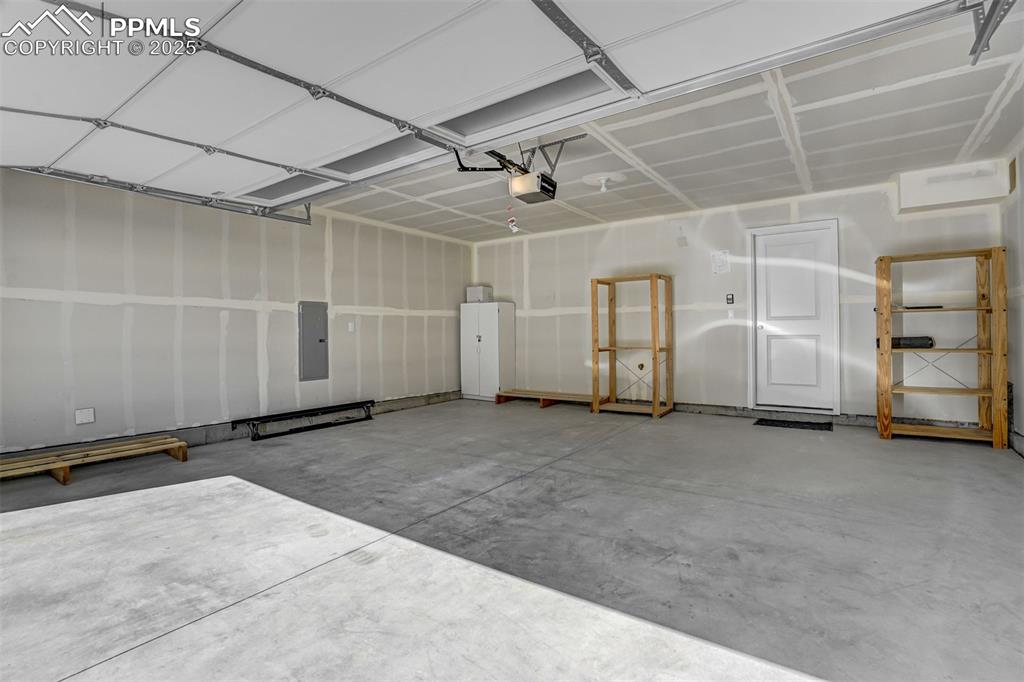 Image 40 of 42: Garage featuring electric panel and a garage door opener