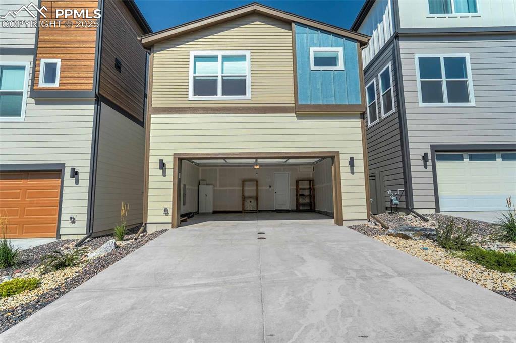 Image 41 of 42: View of front of house with a garage, concrete driveway, and board and batt