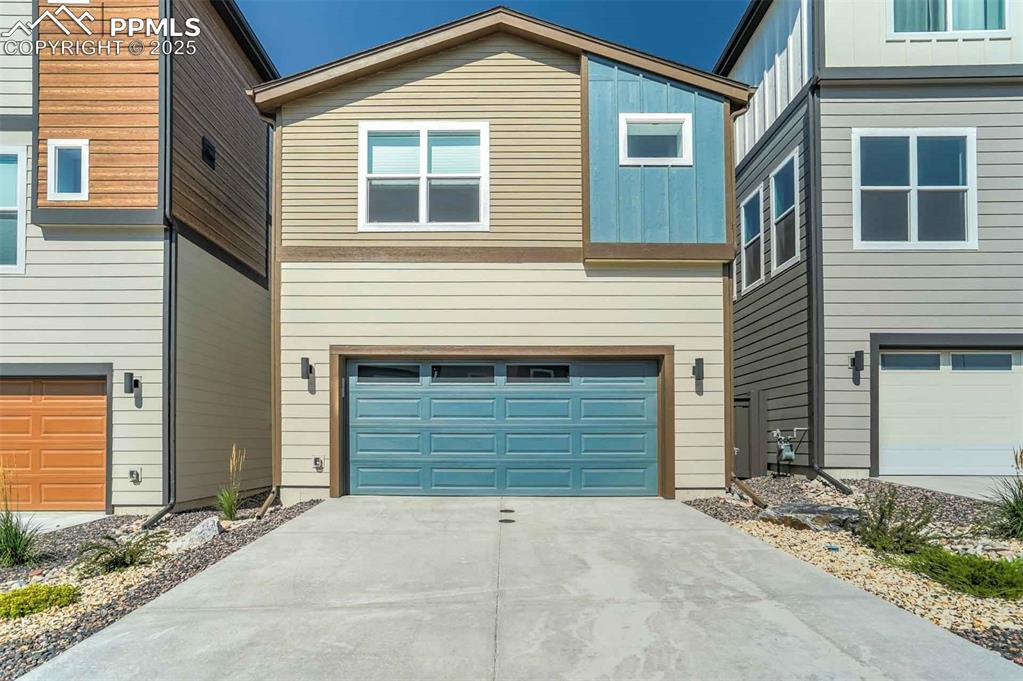 Image 42 of 42: Contemporary house with driveway, an attached garage, and board and batten