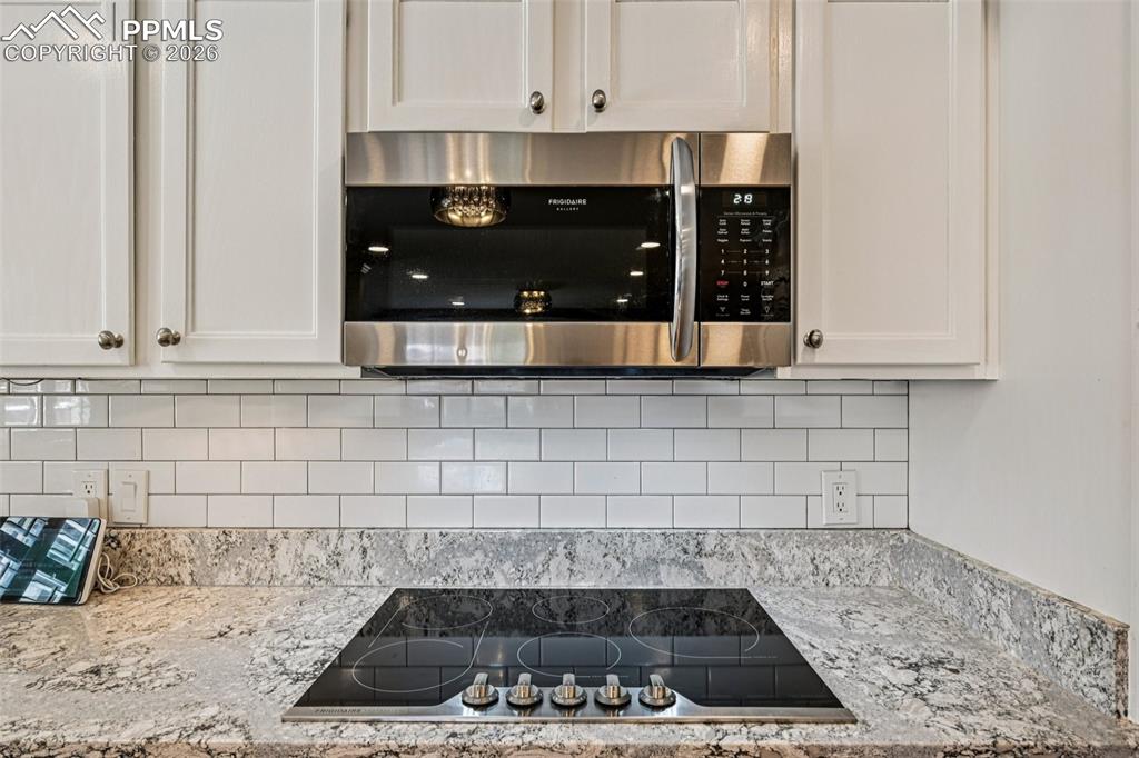 Image 6 of 41: Granite slab counters and tile backsplash