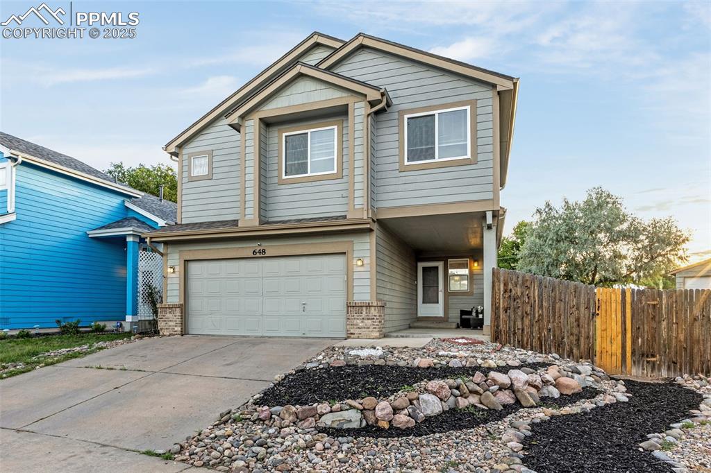 Caption: View of front of property with an attached garage, concrete driveway, and brick siding
