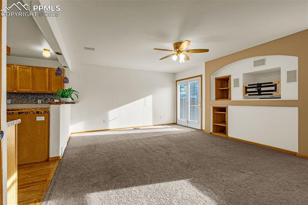 Image 10 of 40: Unfurnished living room with a ceiling fan and light colored carpet