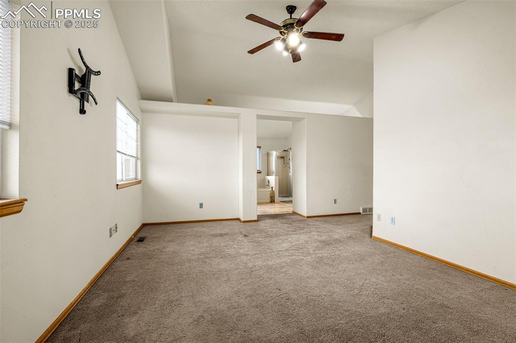 Image 19 of 40: Carpeted empty room with ceiling fan and lofted ceiling