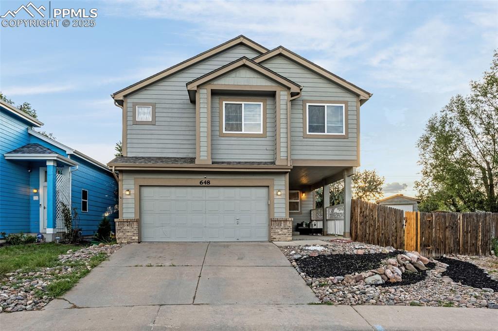 Image 2 of 40: View of front of property featuring an attached garage, driveway, and brick