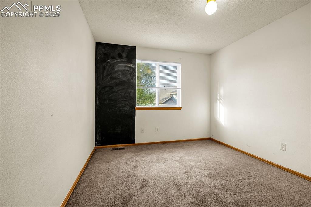 Image 20 of 40: Carpeted empty room with a textured ceiling and baseboards