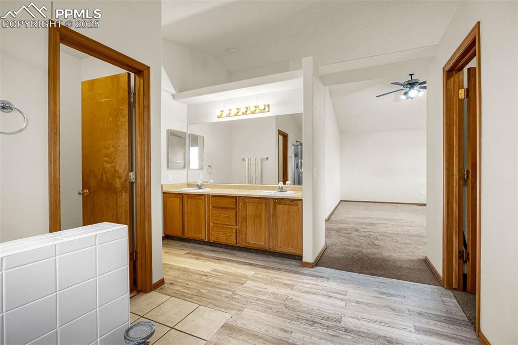 Image 24 of 40: Full bath featuring double vanity, a ceiling fan, and wood finished floors