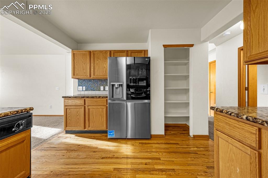 Image 3 of 40: Kitchen featuring stainless steel fridge with ice dispenser, light wood-sty