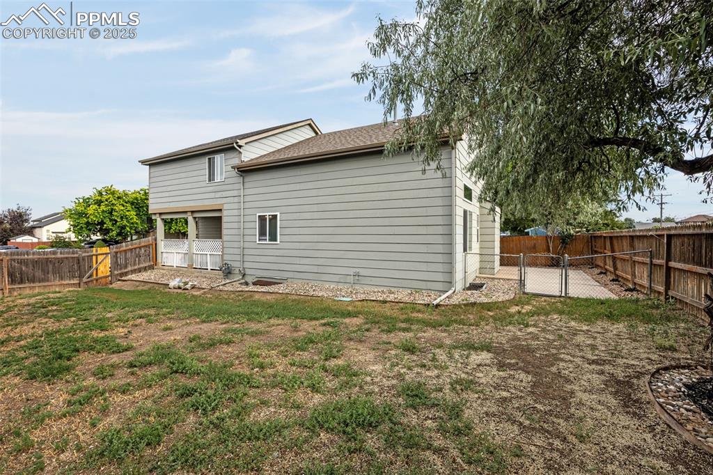 Image 32 of 40: Back of house featuring a fenced backyard