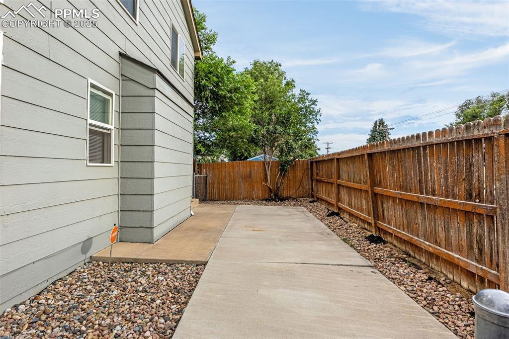 Image 33 of 40: Fenced backyard with a patio area