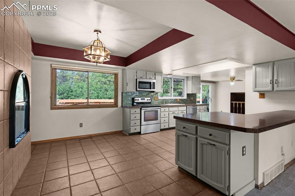 Image 16 of 47: Kitchen with stainless steel appliances and tile flooring