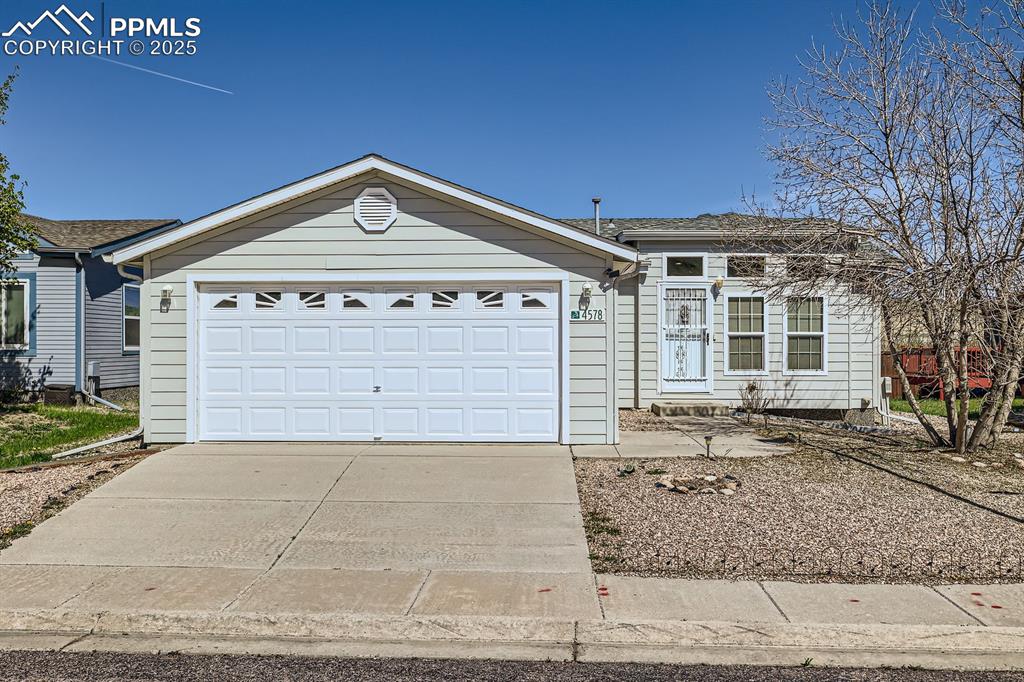 Caption: Ranch-style house with driveway and an attached garage