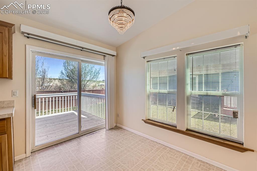Image 12 of 28: Unfurnished dining area with a chandelier and lofted ceiling