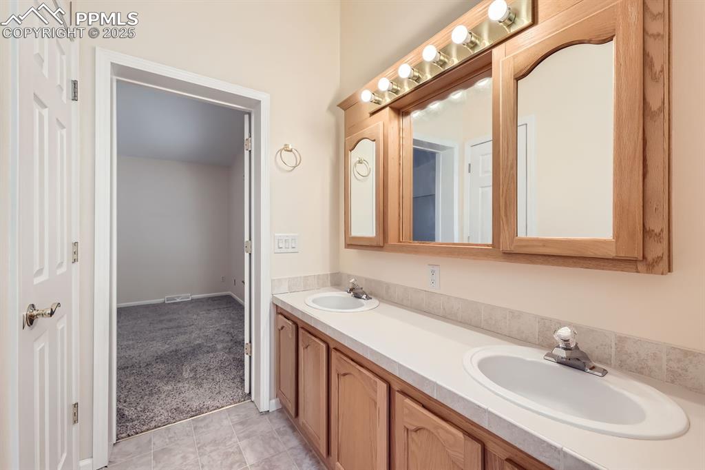 Image 17 of 28: Bathroom featuring double vanity and tile patterned flooring