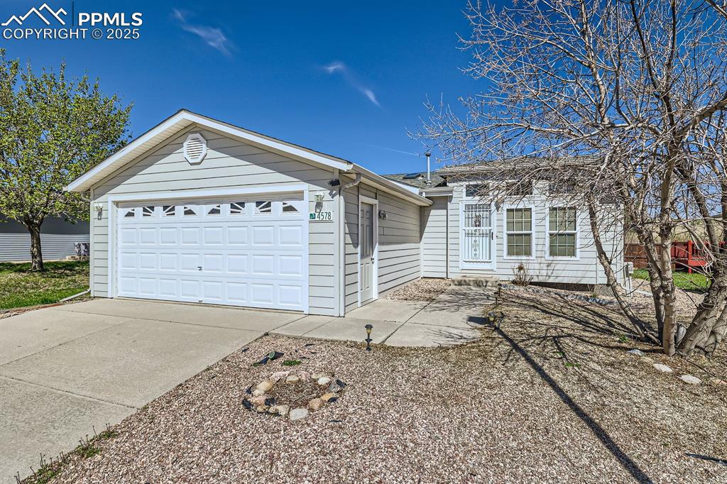 Image 2 of 28: View of front facade featuring an attached garage and concrete driveway