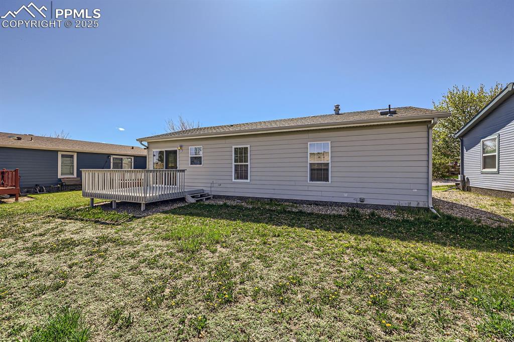 Image 27 of 28: Rear view of house featuring a deck and a yard