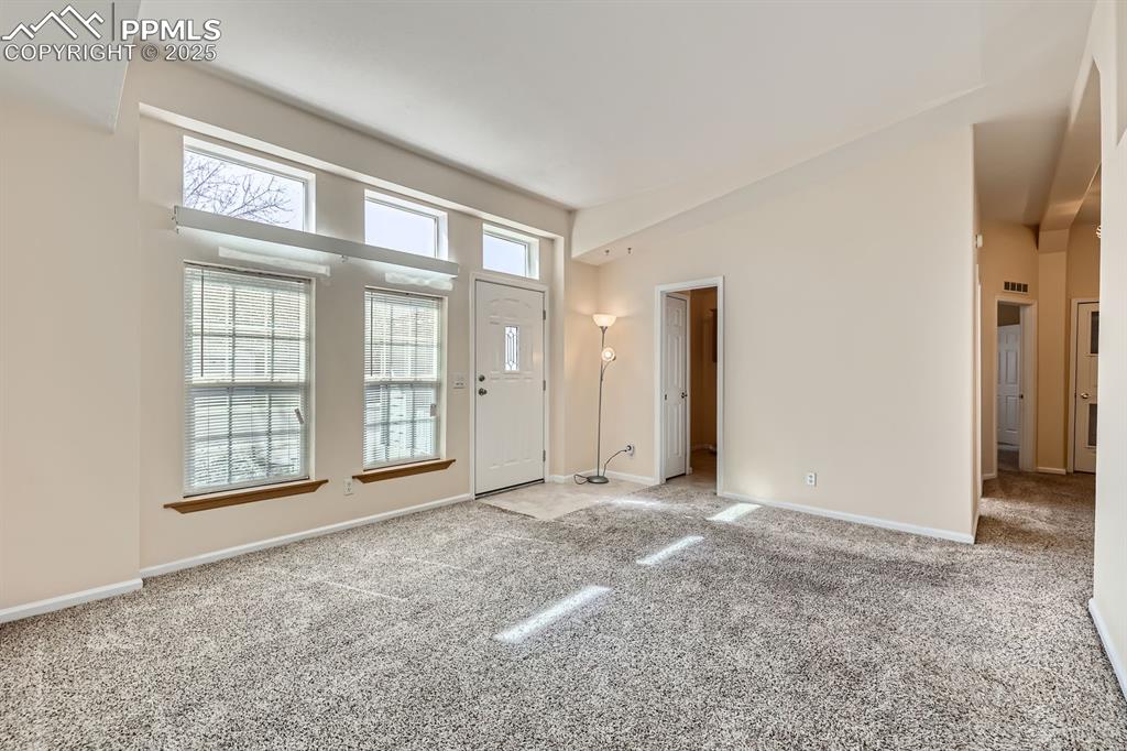 Image 5 of 28: Carpeted foyer with healthy amount of natural light