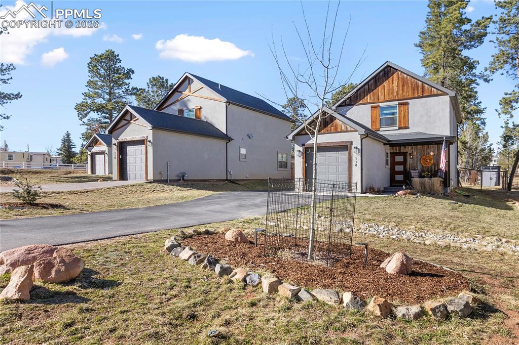 Image 2 of 38: Modern farmhouse style home with a front lawn, a garage, and driveway