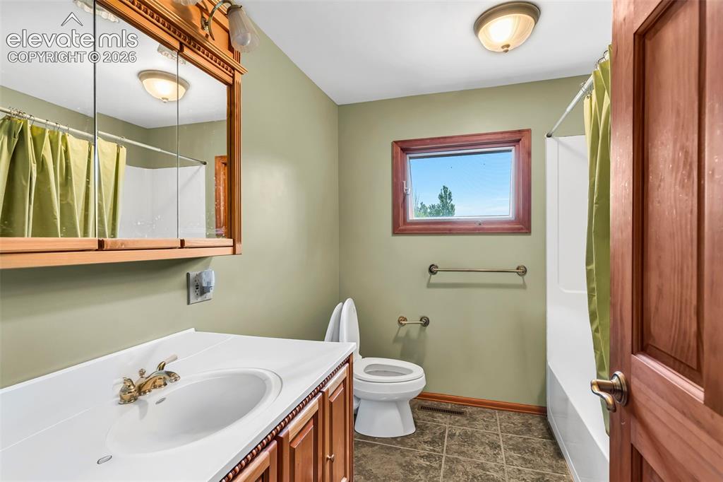 Image 18 of 49: Bathroom featuring a white vanity with an integrated sink, a matching wall-