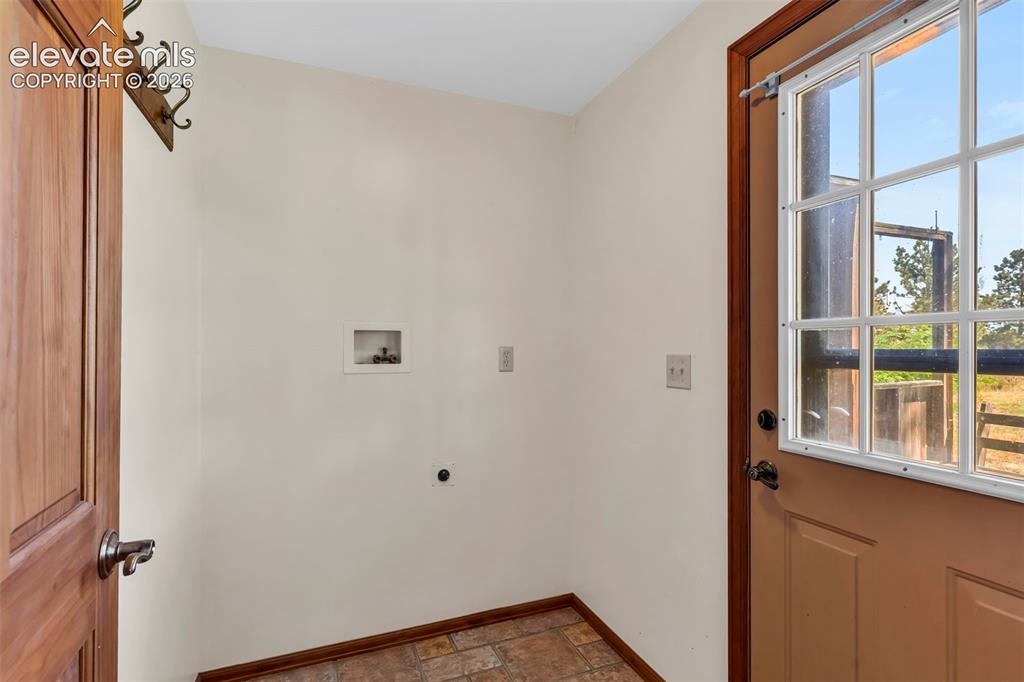 Image 21 of 49: Utility area featuring light-toned walls, wood-finish flooring, and a windo