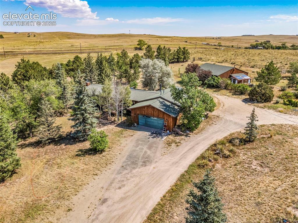 Image 42 of 49: Property featuring multiple structures, extensive natural tree coverage, an