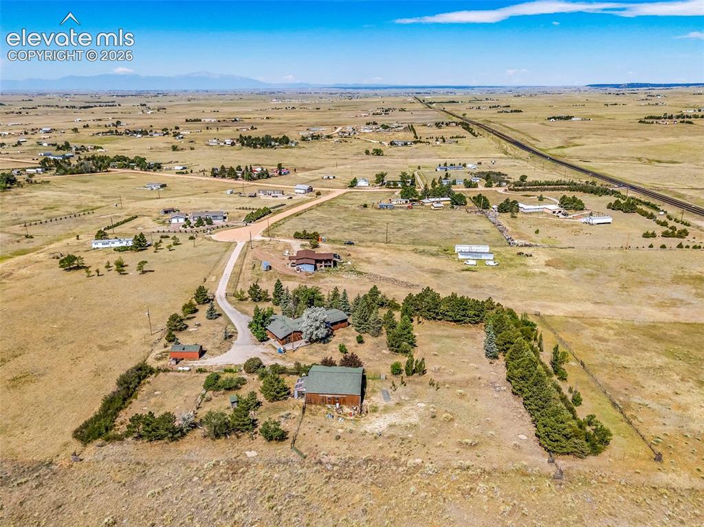 Image 46 of 49: Expansive property featuring multiple structures, mature evergreen landscap