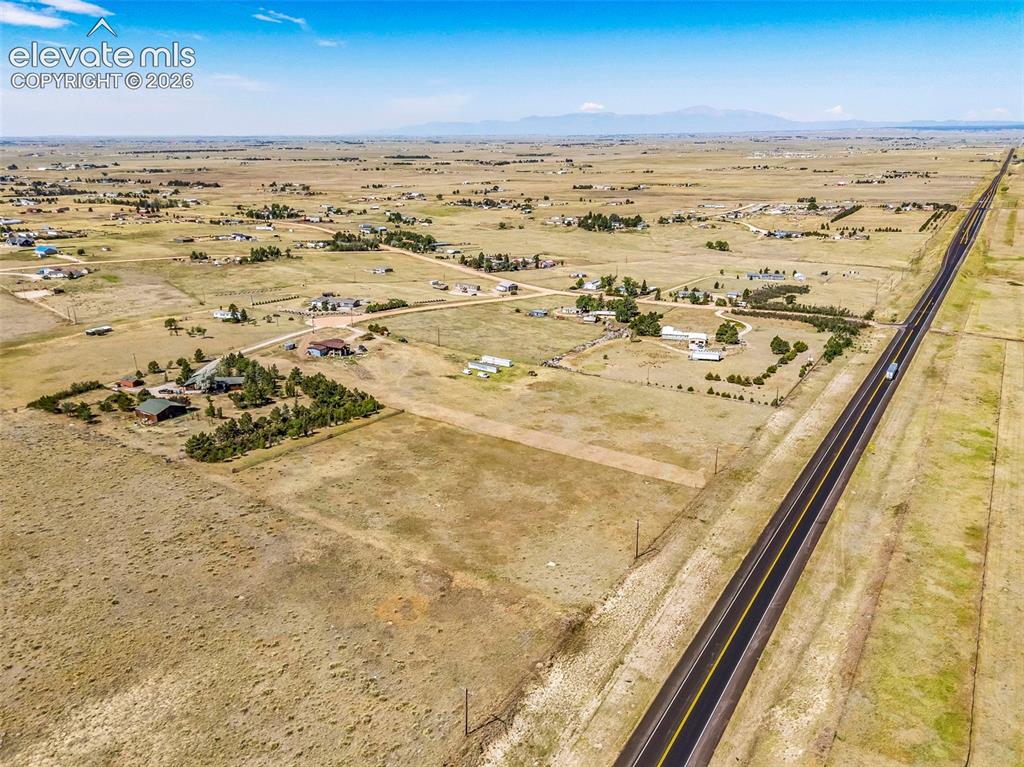 Image 47 of 49: Expansive rural landscape featuring a paved highway, scattered residential