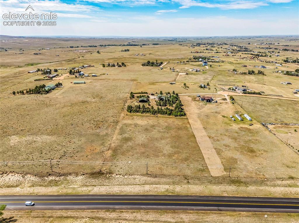 Image 48 of 49: Expansive rural land featuring scattered residential structures and mature