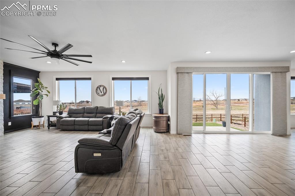Image 12 of 50: Living room with ceiling fan, recessed lighting, and wood finished floors