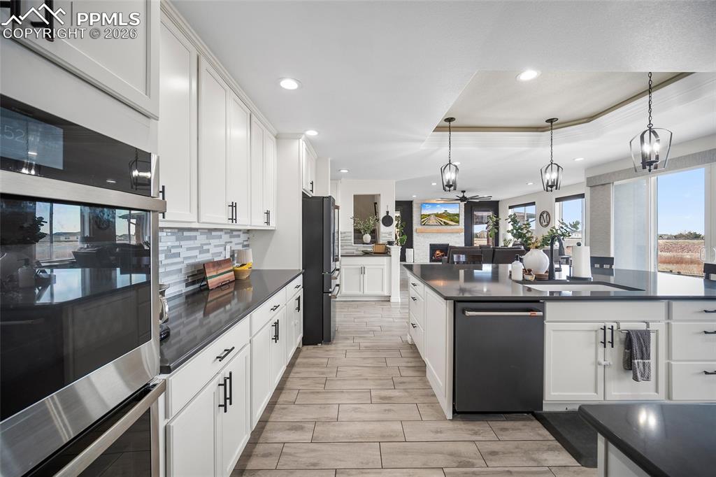 Image 17 of 50: Kitchen with freestanding refrigerator, tasteful backsplash, recessed light