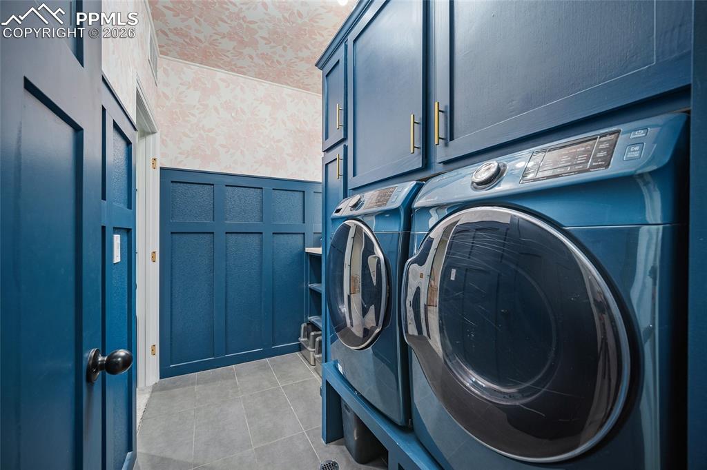 Image 23 of 50: Washroom featuring a decorative wall, independent washer and dryer, light t