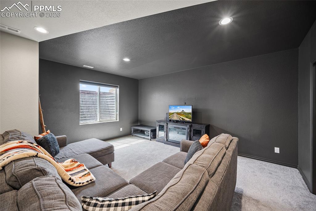Image 40 of 50: Carpeted living area featuring recessed lighting, visible vents, and basebo