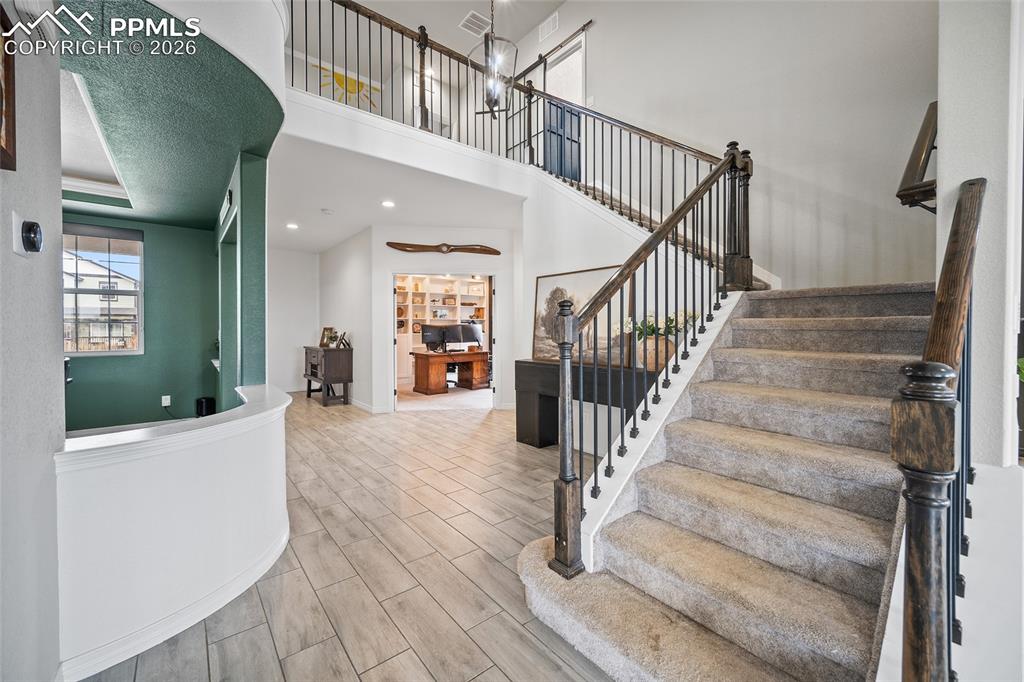 Image 8 of 50: Stairs featuring recessed lighting, open railing, wood finished floors, and