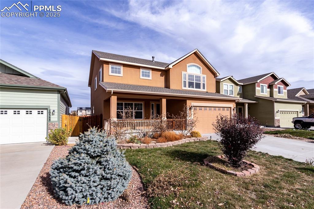 Image 2 of 49: View of front of home with stucco siding, concrete driveway, stone siding,