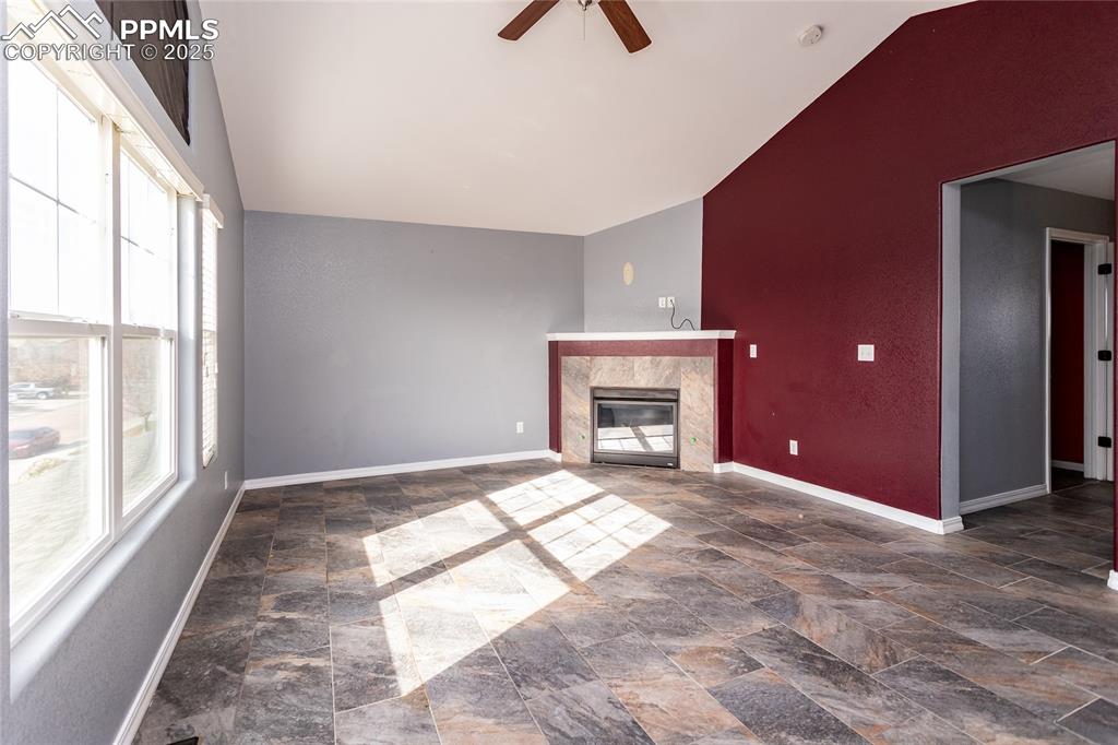 Image 21 of 49: Unfurnished primary bed room with a high end fireplace, ceiling fan, dark s