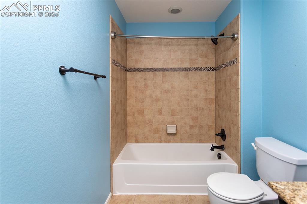 Image 37 of 49: Full bath featuring a textured wall, bathing tub / shower combination, and