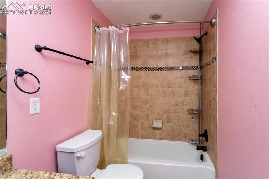 Image 41 of 49: Full bath featuring a textured wall, shower / bathtub combination with curt