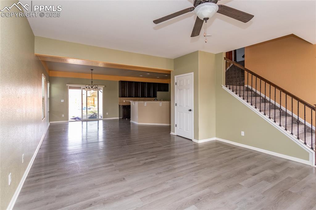 Image 9 of 49: Unfurnished living room featuring, stairs, light wood-type flooring, and a